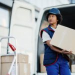 black-female-courier-unloading-cardboard-boxes-from-van